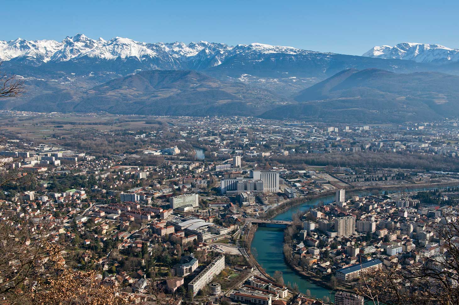 Aerial view of the La Tronche health campus and the Belledonne mountain range in winter.