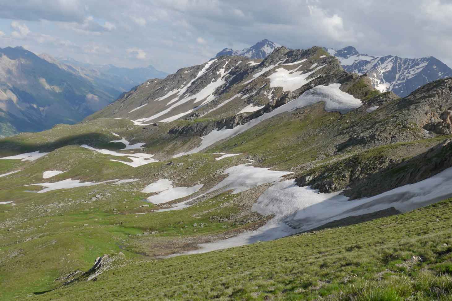 Enneigement de début d’été dans le vallon de Roche Noire à proximité du col du Lautaret, un site modèle dans lequel les dynamiques couplées de l’enneigement et de la végétation sont étudiées de très près dans le cadre des activités de recherche et d’obser