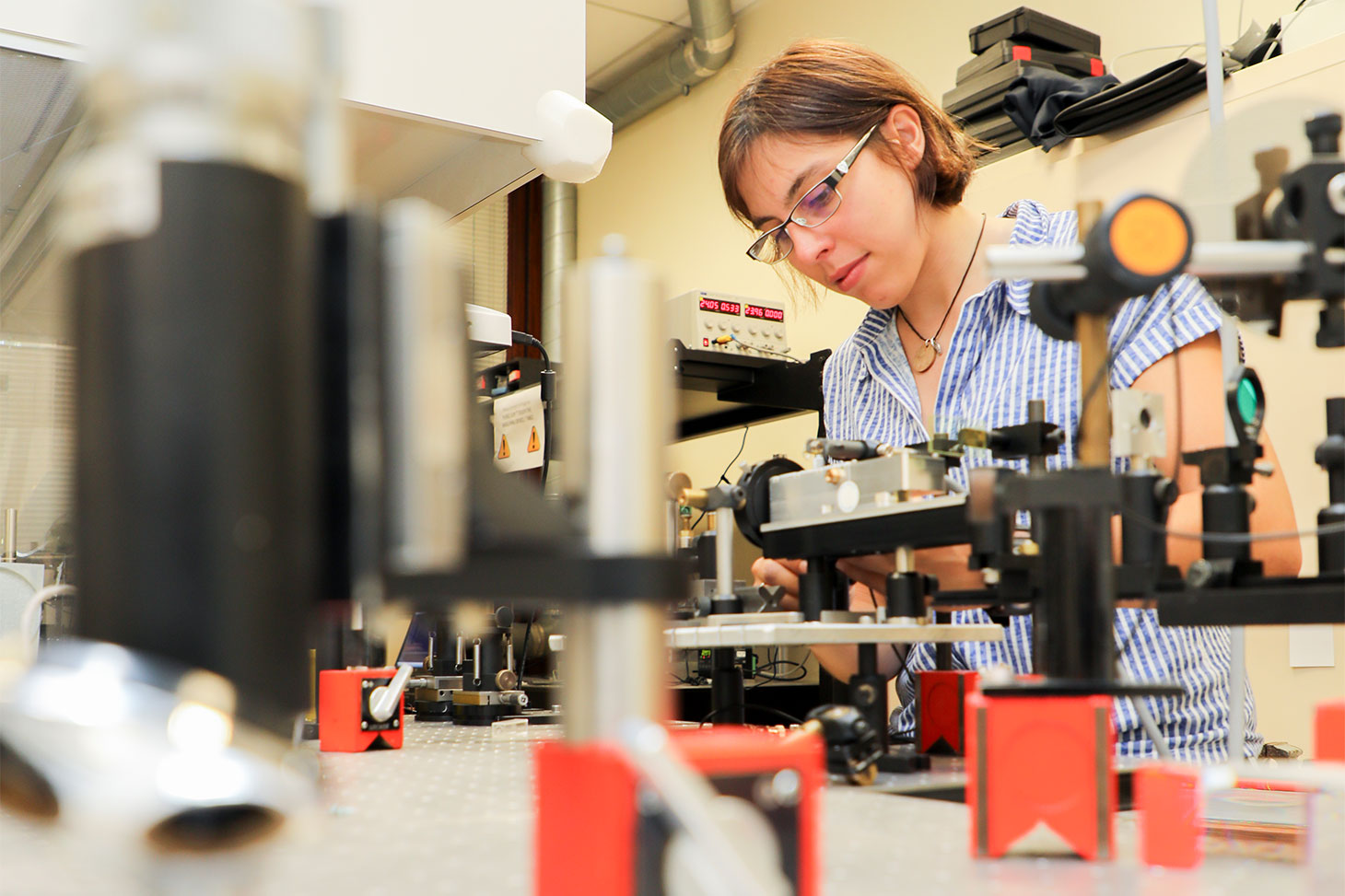 Une chercheuse manipule un instrument scientifique dans un laboratoire