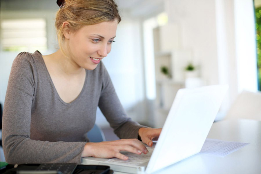 Une étudiante travaille sur son ordinateur portable