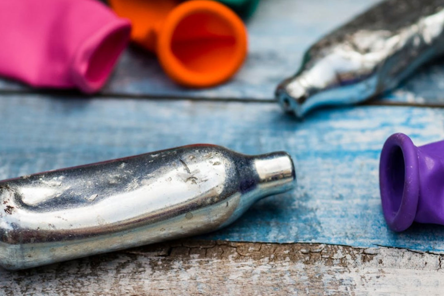 Des cartouches de protoxyde d’azote vides, posées à côté de ballons de baudruche utilisés pour inhaler le gaz. Lenscap Photography/Shutterstock